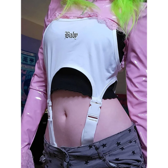 White Baby cut-out bodysuit with garter straps over black underwear, pink translucent jacket, neon green hair.