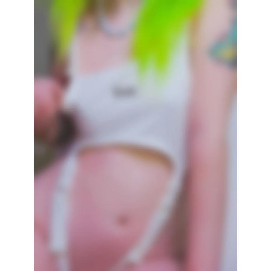 Model in a white cut-out bodysuit with neon green hair, midriff exposed.
